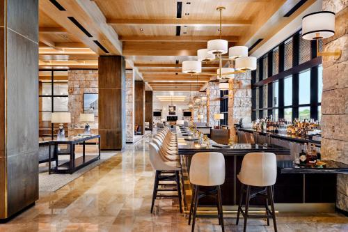 弗赖拉辛Omni PGA Resort Frisco-Dallas的酒吧餐厅里的酒吧,酒吧的凳子