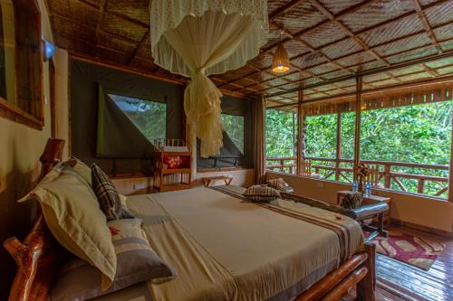 BugambiraRushaga Gorilla Lodge的一间设有床铺的卧室,位于带窗户的房间内