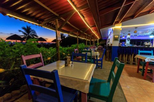 拉斯拉哈斯Las Lajas Beach Resort的一间带桌椅的餐厅和酒吧