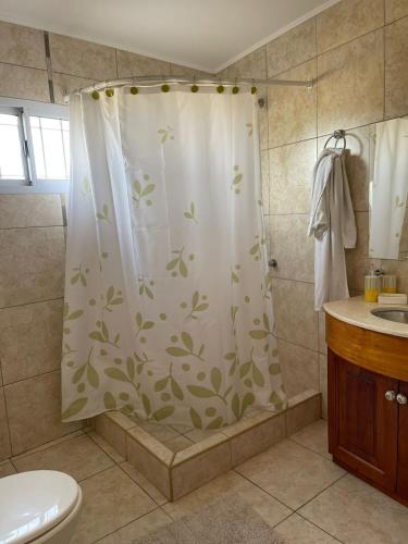 马拉圭Casa moderna en zona tranquila的浴室设有淋浴帘和叶片。