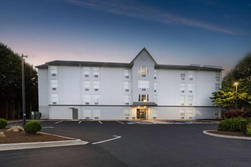 阿什维尔Rodeway Inn & Suites near Outlet Mall - Asheville的一座大型白色建筑,设有停车场