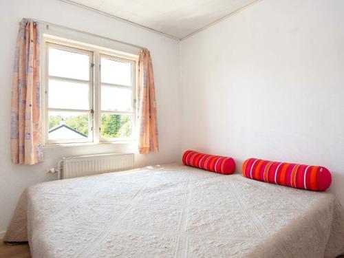 诺德堡Holiday home Nordborg XXVI的一间卧室配有一张带红色枕头的床
