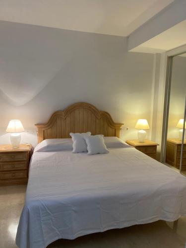 萨阿拉德洛斯阿图内斯Casa del Mar的一间卧室配有一张带两盏灯的大型白色床。