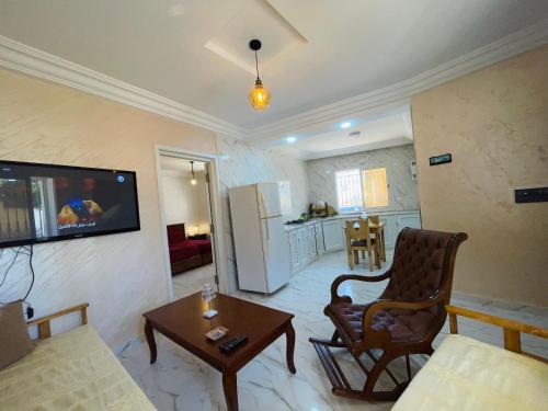 Ghār al MilḩSeaside Guest House的客厅配有沙发和墙上的电视