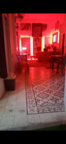 安曼Jawal Hotel的客厅配有红色灯光、沙发和椅子