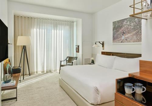 丹佛哈尔西恩樱桃溪酒店的一间酒店客房,配有一张白色的床和一张书桌