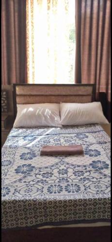 安曼Jawal Hotel的一张带木头床头板和枕头的床