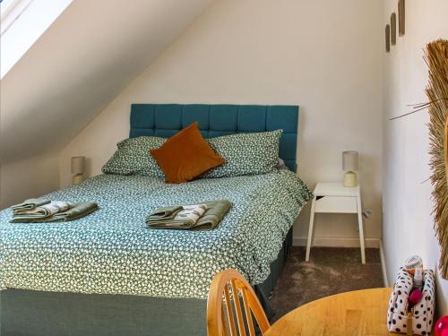 LenwadeNo, 2 Badger Sett-uk44307的一间卧室配有一张带蓝色床头板的床和一张桌子