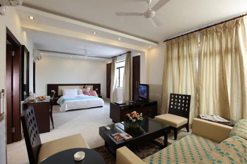 新德里The Legend Inn Delhi的一个带床和沙发的大客厅