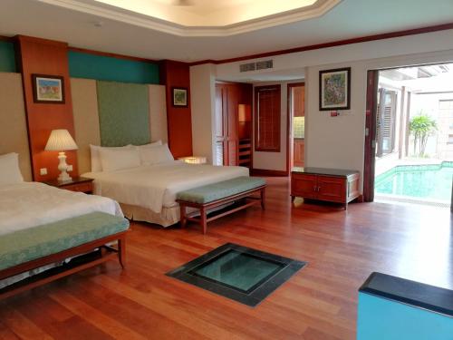 波德申Wonderland Private Pool Villas at Port Dickson的酒店客房带两张床和一个游泳池