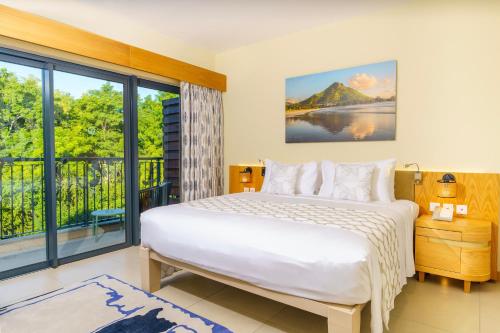 巴拉克拉瓦Ocean's Creek Beach Hotel的一间卧室设有一张床和一个大窗户