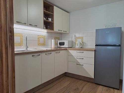 克拉尼斯卡戈拉Apartments Pr'Krštano的厨房配有白色橱柜和冰箱。