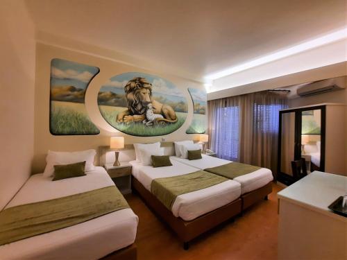 法蒂玛哈利路亚酒店的酒店客房设有两张床,墙上挂着狮子