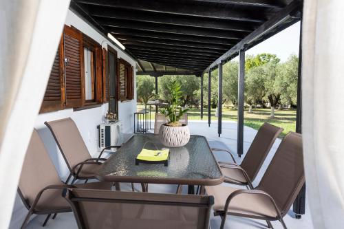 奥马斯帕纳吉亚斯Casa Alelia Lagonisi的门廊上配有桌椅的天井
