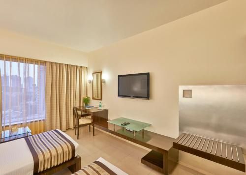 孟买克利须娜皇宫酒店的配有一张床和一张书桌的酒店客房