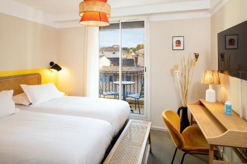 普罗旺斯艾克斯Hôtel Escaletto的配有一张床、一张书桌和一扇窗户的酒店客房