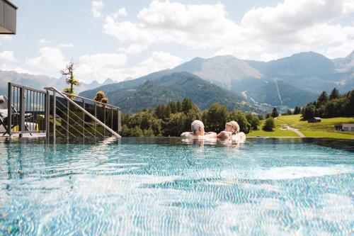 拉迪斯Alpine Resort Goies Superior的两人在一座山地游泳池内