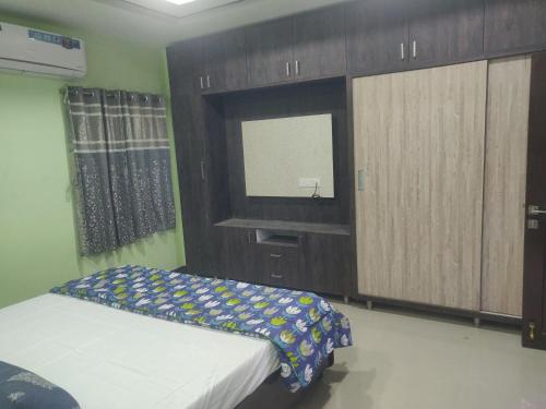 卡基纳达SRINILAYAM LUXURY STAY HOMES的一间卧室配有一张床、木制橱柜和镜子
