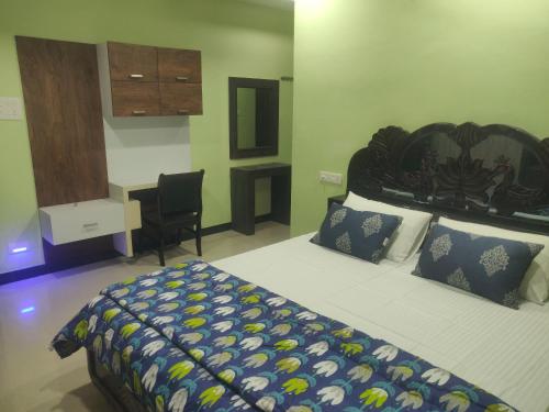 卡基纳达SRINILAYAM LUXURY STAY HOMES的一间卧室配有一张大床和一张书桌