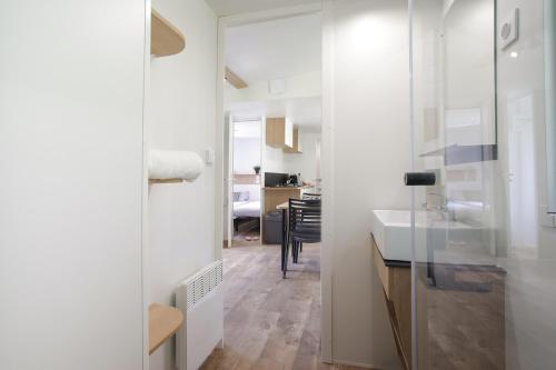 弗洛朗维尔Camping Le Florenville的白色的厨房配有水槽和镜子