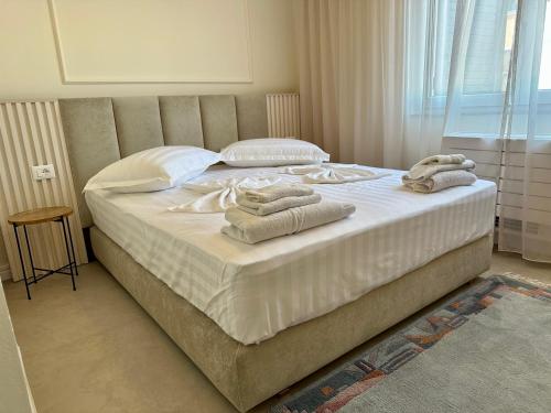 都拉斯Sea View Apartments ELDO的一间卧室配有一张大床和毛巾