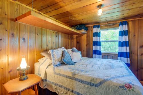 Hubbard LakeCharming Michigan Cottage with Sunroom and Lake Access的小木屋内一间卧室,配有一张床