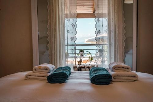 斯皮里登科夫Neptune Sea House - Beachfront的一间卧室配有带毛巾的床和窗户。
