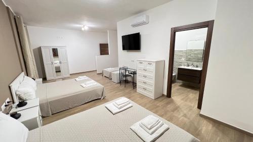 莫诺波利Cala Portavecchia的一间卧室设有两张床、一个水槽和镜子
