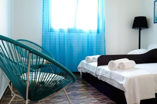 迈加洛丘里Maria’s Sunset House的一间卧室配有两张床和一张绿色椅子