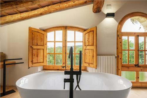SerinyàMas Cufí的窗户客房内的白色大浴缸