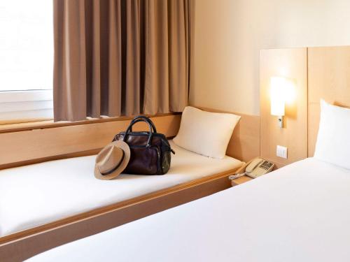 辛特拉宜必思里斯本辛特拉酒店的坐在酒店房间床上的袋子