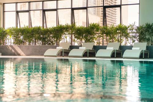 下龙湾Hotel Soleil Ha Long, Trademark Collection by Wyndham的一座带白色躺椅的游泳池