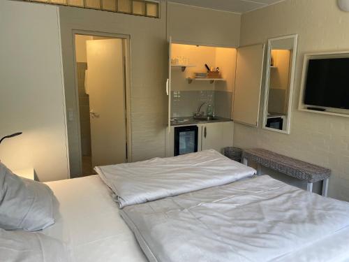 斯凯拜克Motel Rovli的一间带白色床的卧室和一间厨房