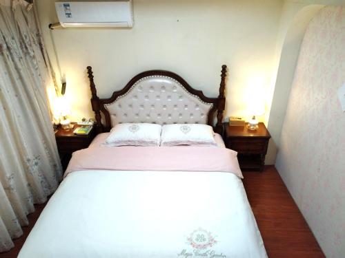 贵阳空中花园民宿 贵阳火车站店的一间卧室配有白色床和2个床头柜