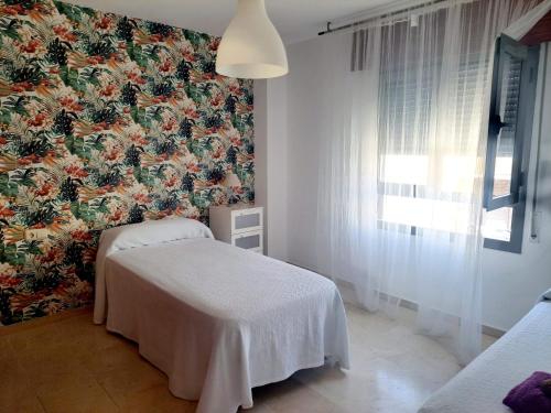 休达Beatiful and full-equipped flat in the city center的客房设有两张床和花卉壁纸。