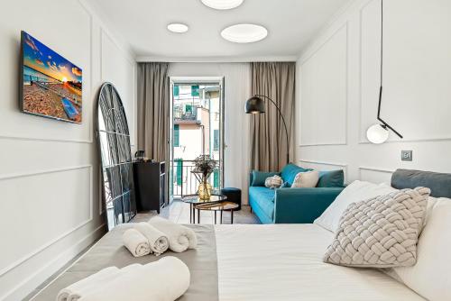 里奥马哲雷EC Luxury Rooms的白色的客房配有床和蓝色的沙发