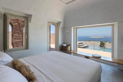 阿克罗蒂里Serra Exclusive Suites的一间卧室配有一张床,享有海景