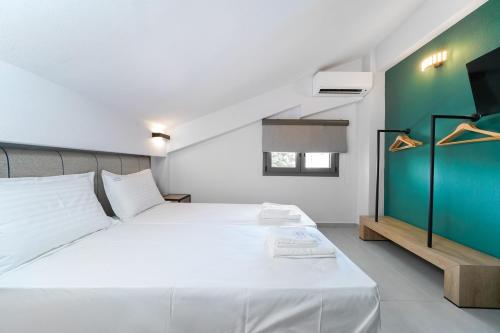 克里斯阿穆迪亚Aerino Luxury Villas的卧室配有白色的床和绿色的墙壁
