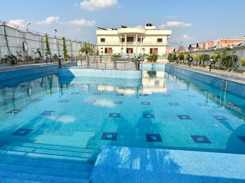 AyodhyaRoyal Heritage Hotel & Resort的大楼前的蓝色海水大型游泳池