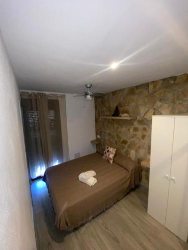 塞特尼尔Casita en el Tajo的一间卧室设有一张床和石墙