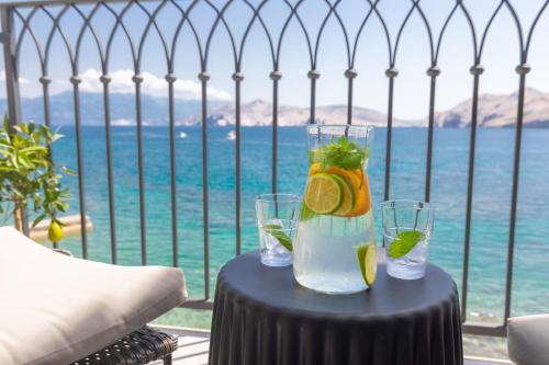 巴斯卡Seafront Baska Apartment的一张桌子,两杯水,享有海景