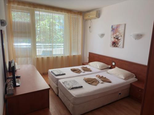 布尔加斯Complex Nev的一间小卧室,配有两张床和窗户