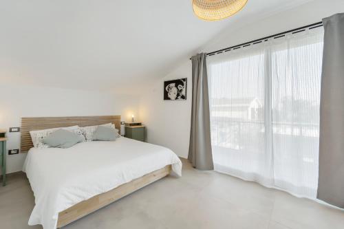 苏富提La Pimpinella的白色的卧室设有床和大窗户