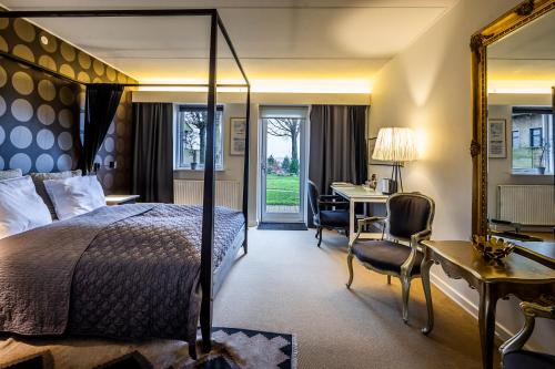 欧德尔诺思明得可洛酒店的酒店客房设有一张大床、一张桌子和椅子。