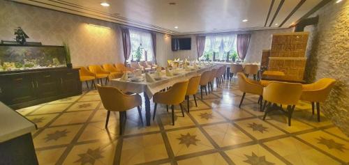 巴尔代约夫Villa Florencia的一间带长桌和黄色椅子的用餐室