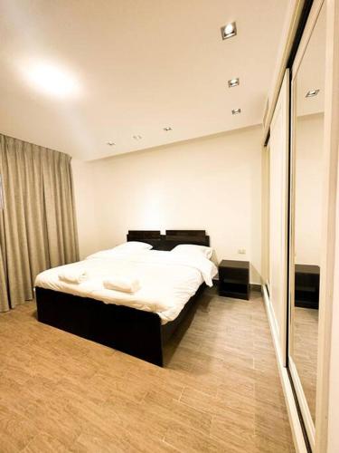 Umm Uthainahcentral apartment for rent 29的一间卧室配有一张床和一面大镜子