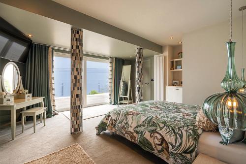 纽卡斯尔NEWCASTLE stunning sea views & forest backdrop的一间卧室配有一张床、一张书桌和一个窗户。