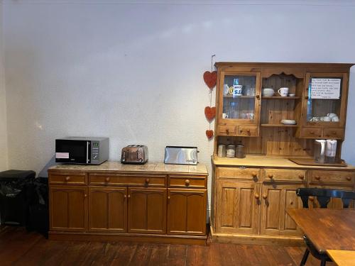 伯恩茅斯THE LODGE BOURNEMOUTH的厨房配有木制橱柜和台面上的微波炉