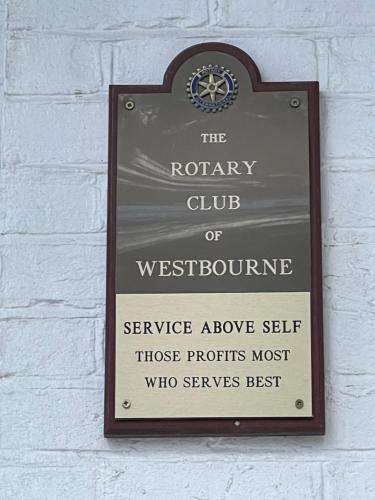 伯恩茅斯THE LODGE BOURNEMOUTH的白色砖墙上标有西本肾上腺素保修俱乐部的标志