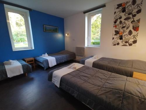 Gétigné鲁弗磨坊乡村假日公园的酒店客房,设有三张床和两扇窗户